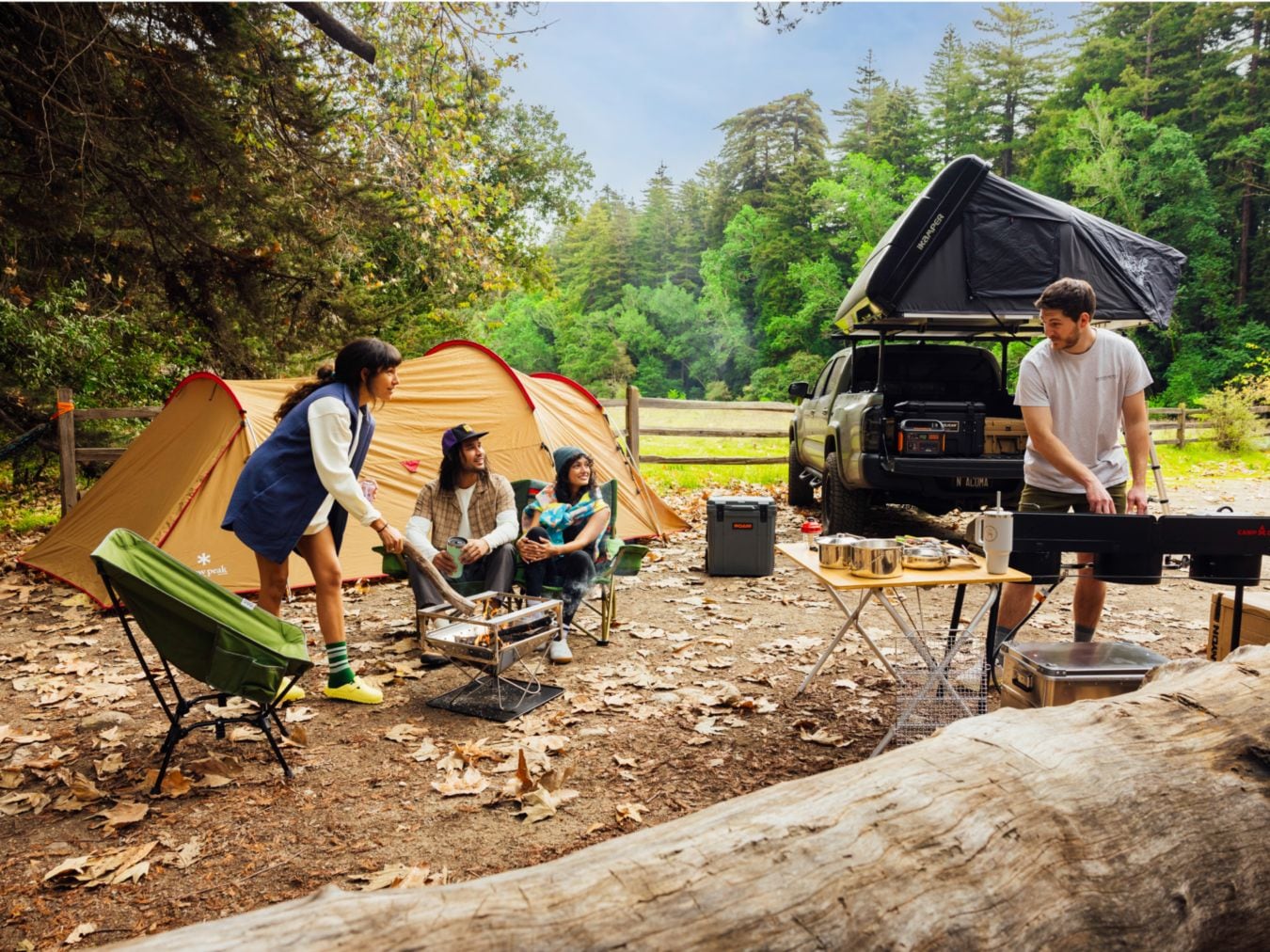 A group of people at a campground prepare a meal and stoke a fire.